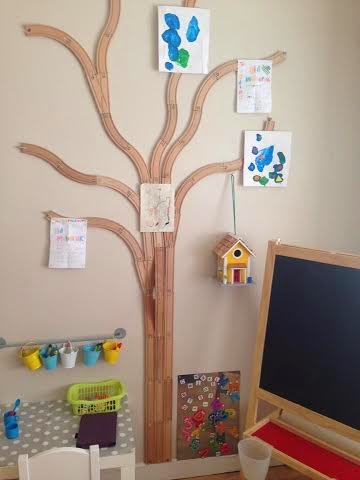 Wooden train tracks made into a tree and used to display children's art on the walls