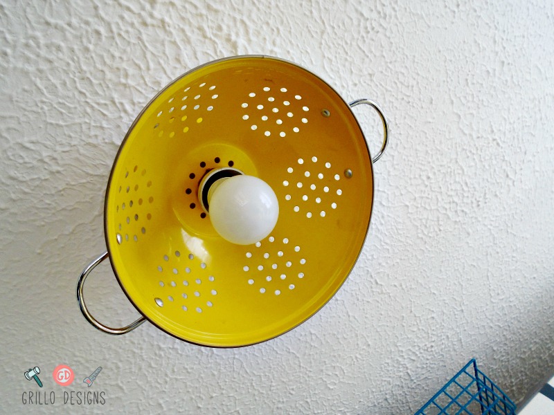 Yellow collander turned into a light fixture on the ceiling