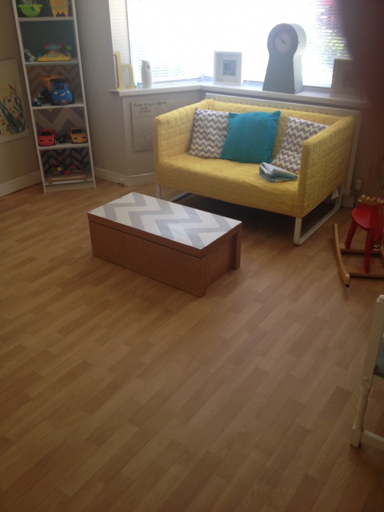Before picture of the playroom showing a yellow sofa