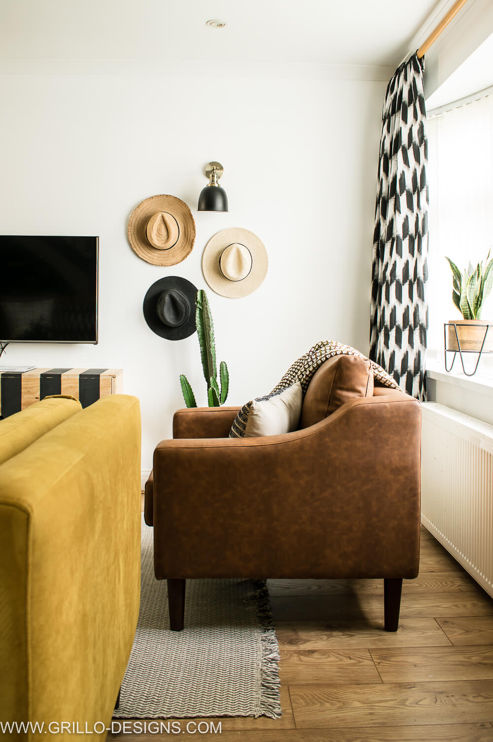 spring living room tour with faux leather arm chair and gallery hat wall in the background