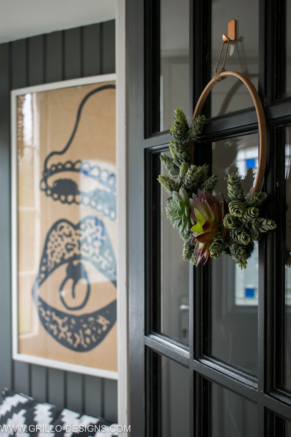 Succulent wreath hanging from glass panel doors from a hook