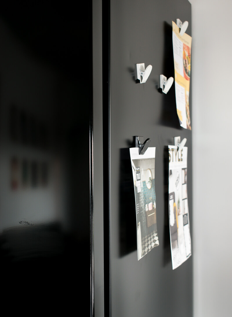 Fridge magnets on the side of a black samsung fridge 