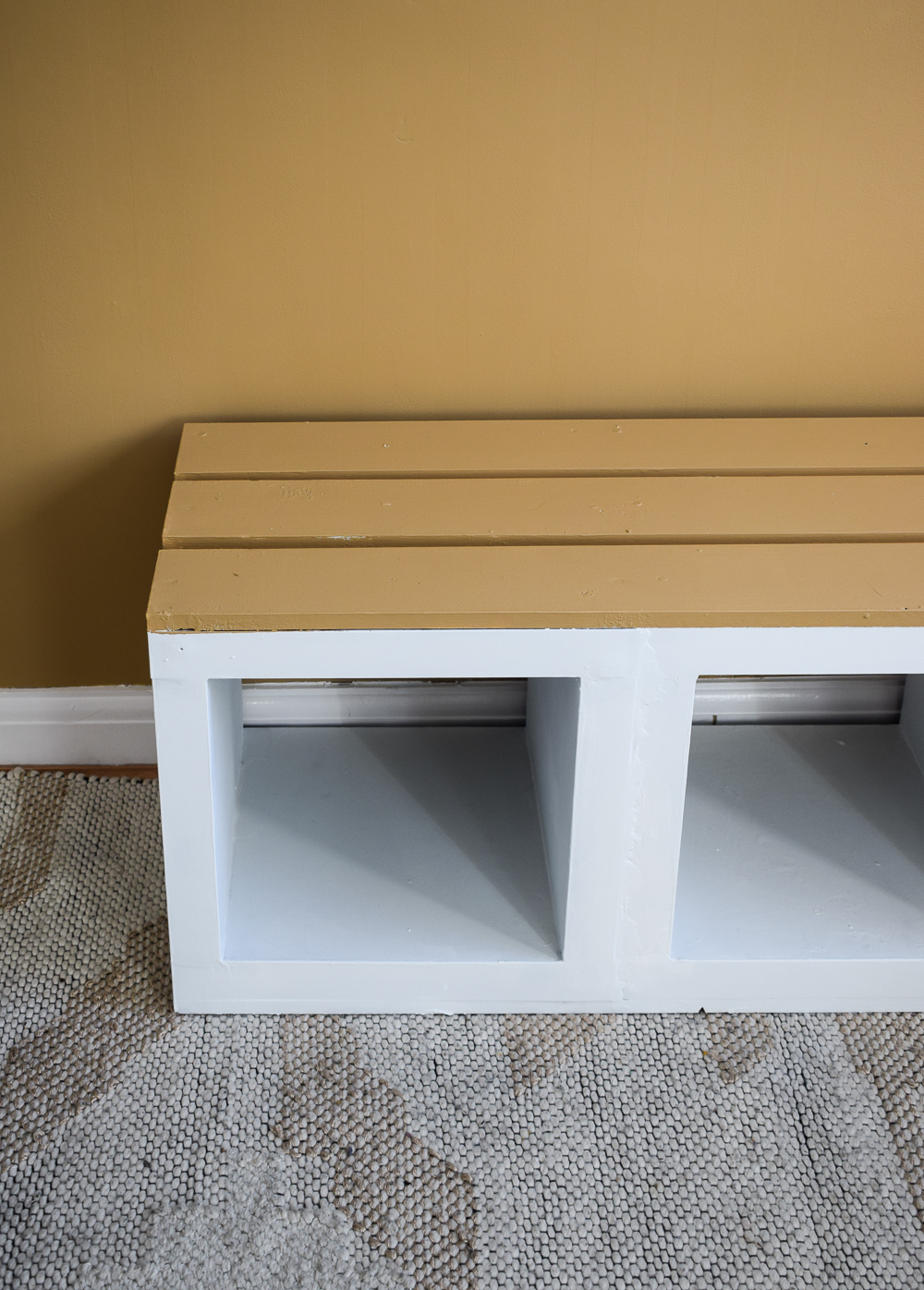 IKEA KALLAX bench after being painted. The top is brown and the rest of the bench is white