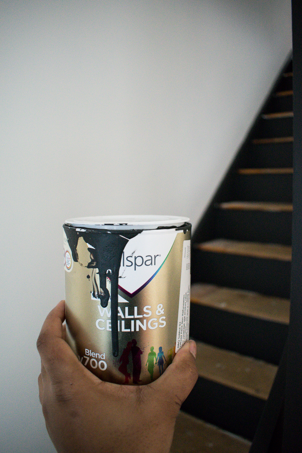 Image of me holding can of vaslpar paint next to the stairs