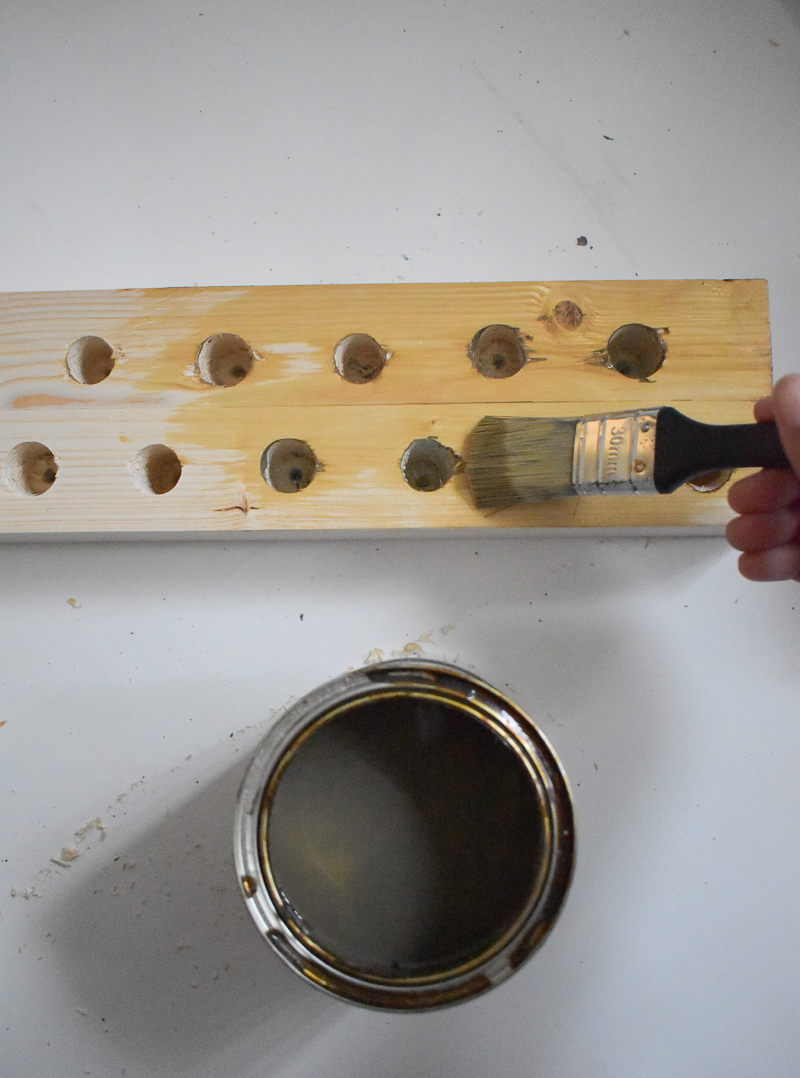 Applying ronseal stain with paint brush to candle stick holder 