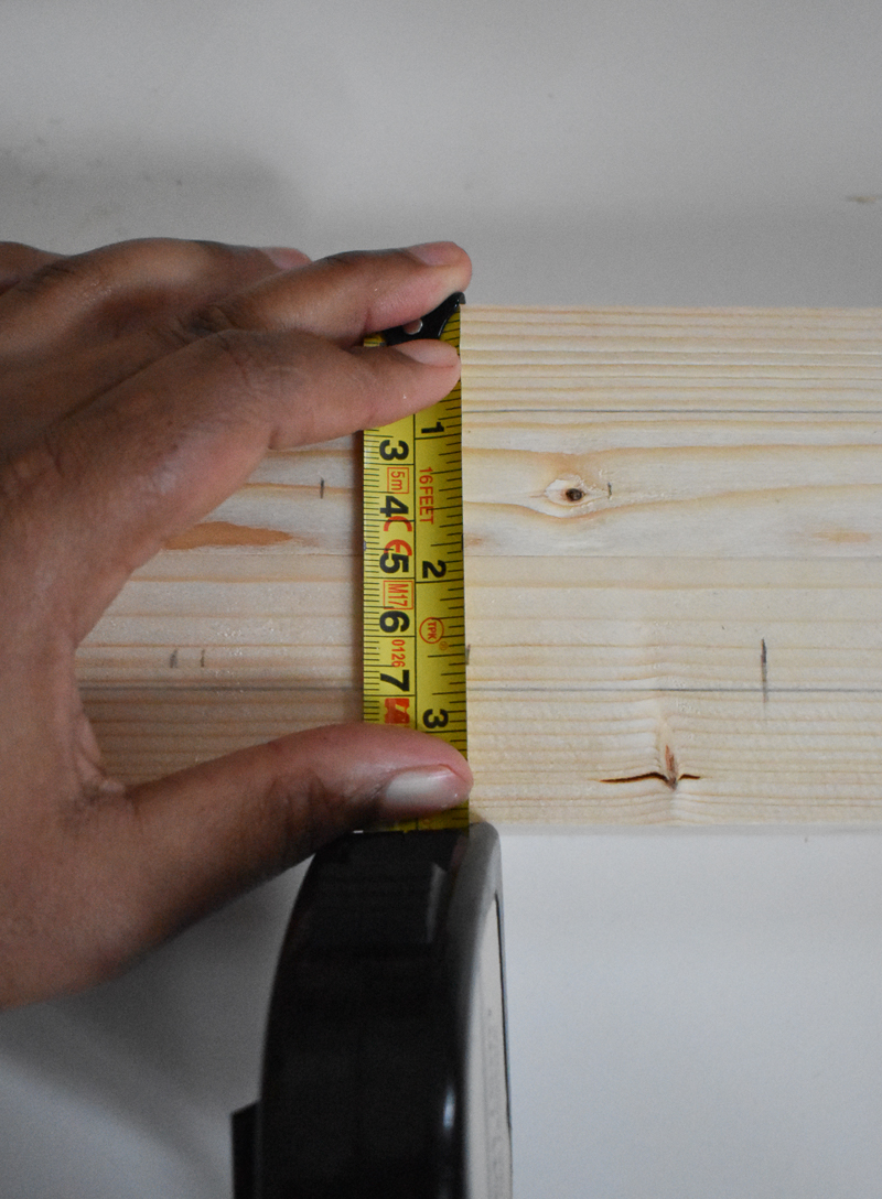 Image of my hand holding the tap measure against the wood