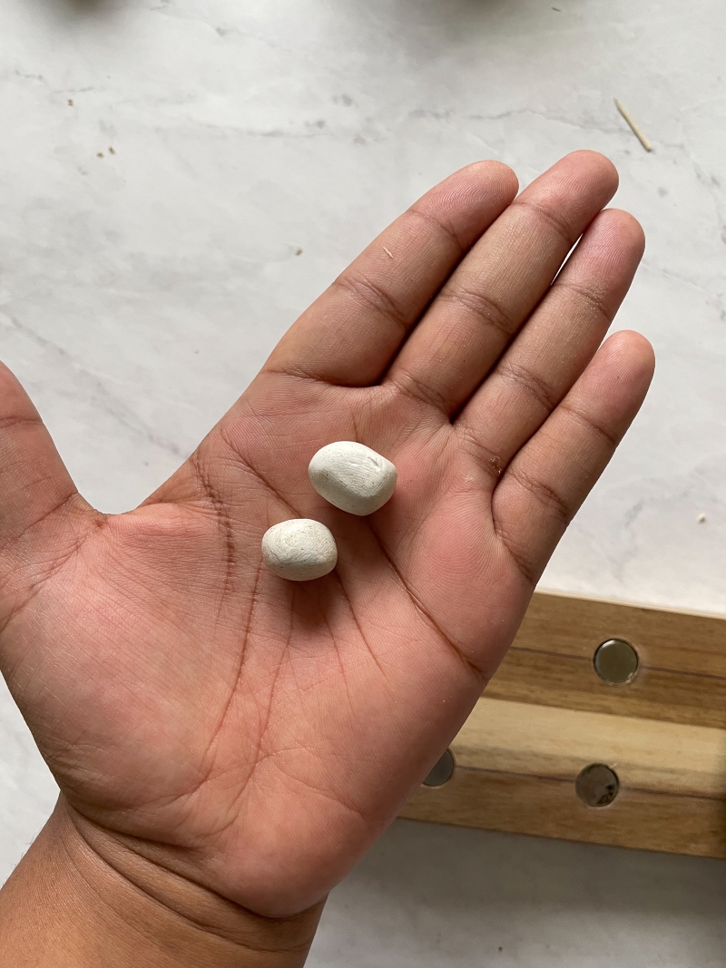 Close up of two rolled up balls of white sugru in my hand