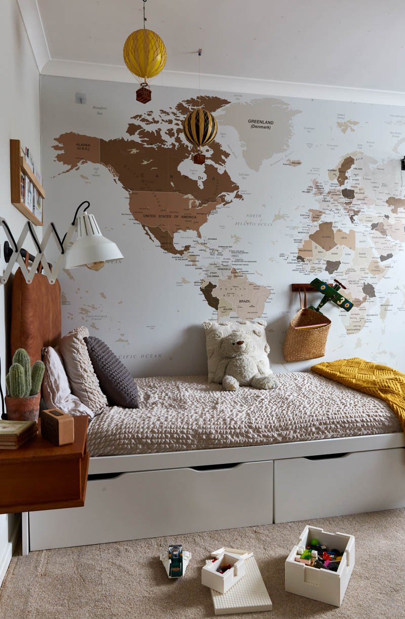 Map wall mural on wall above bed in travel themed boy's bedroom