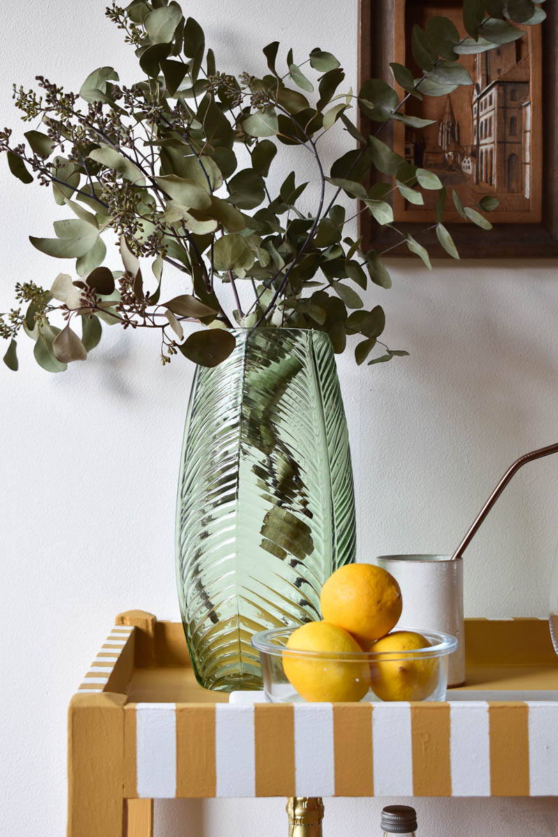 close up of DIY bar cart with lemons in a glass bowl and a vase with greenery