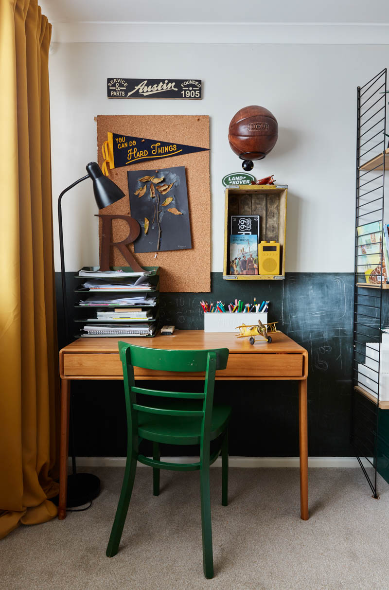Desk wall with desk, green chair pepsi crate on wall and cork bulletin board