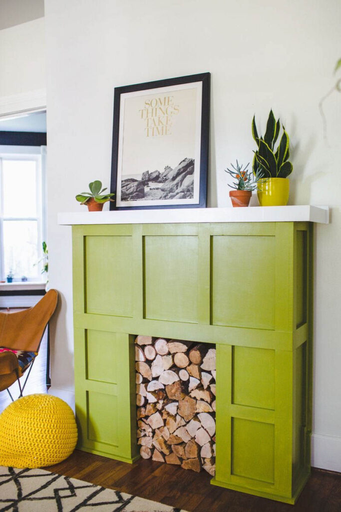 green faux fireplace with logs stacked to fill it inside