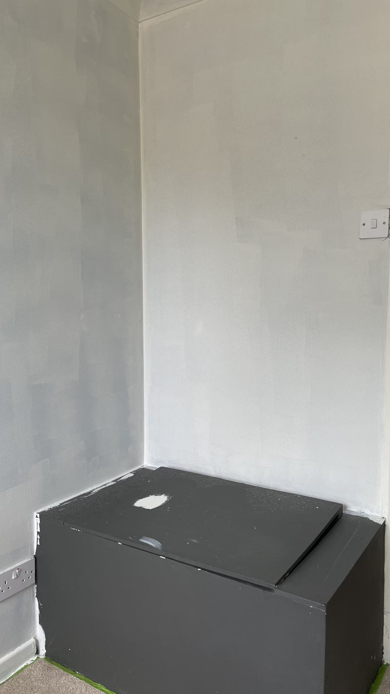 Black walls have been painted over in white before the warm white and yellow are painted on. This photo shows the bulkhead / seat which is still black